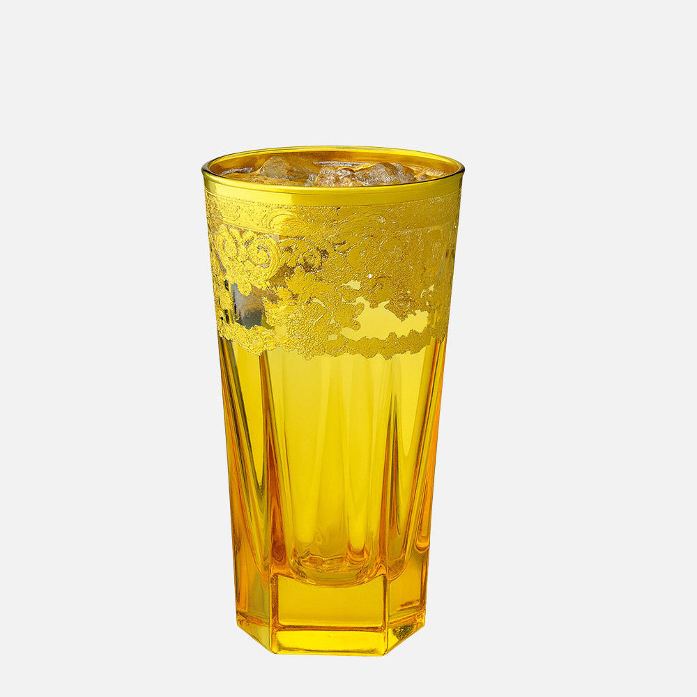 A translucent yellow glass tumbler with a faceted, ribbed design and a frosted pattern near the top, shown on a solid light gray background.